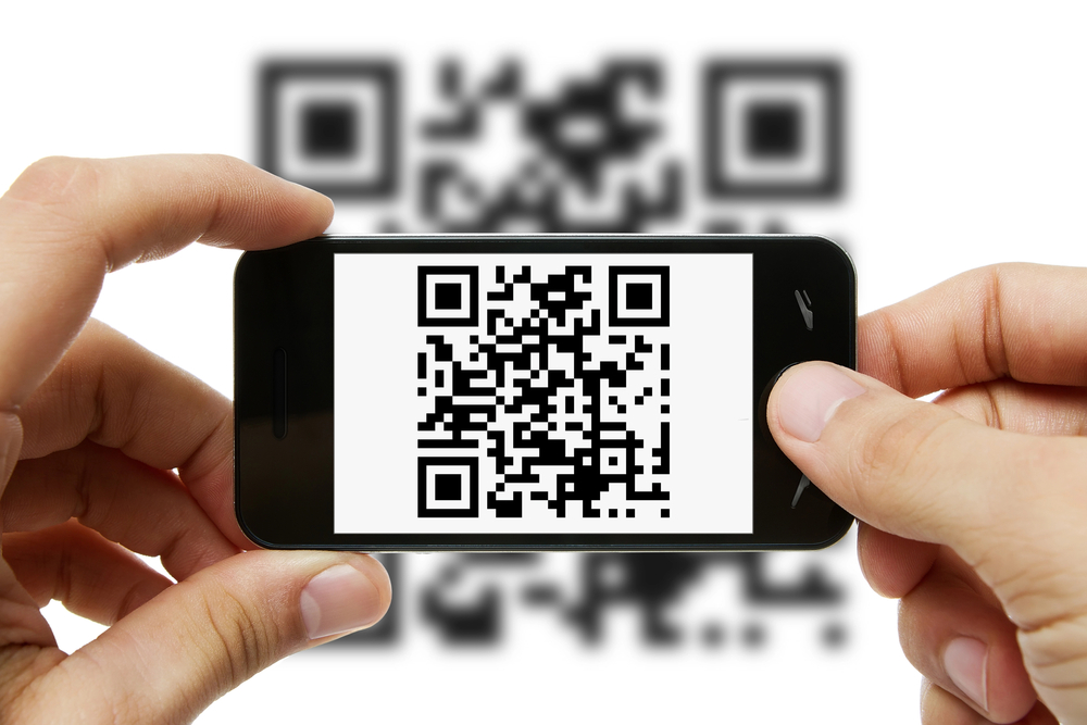 Hands holding a phone as it scans a QR code